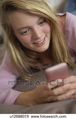 Teenage Girl Lying In Bedroom Using Mobile Phone View Large Photo Image Stock Photo - Teenage Girl Lying In Bedroom Using Mobile Phone. Fotosearch