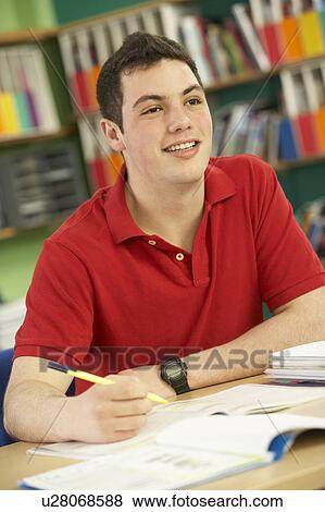 Stock Photo - Teenage Male Student In Working In Classroom. Fotosearch