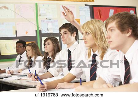 Stock Photo - Teenage Student Answering Question Studying In Classroom. Fotosearch