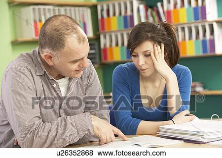 Stock Photo - Teenage Student In Classroom With Tutor. Fotosearch