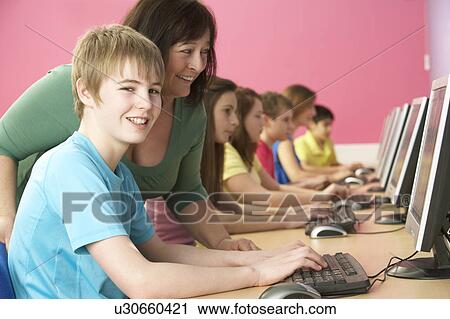 Stock Image - Teenage Students In IT Class Using Computers In Classroom With T. Fotosearch