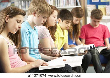 Picture - Teenage Students In Library Reading Books. Fotosearch
