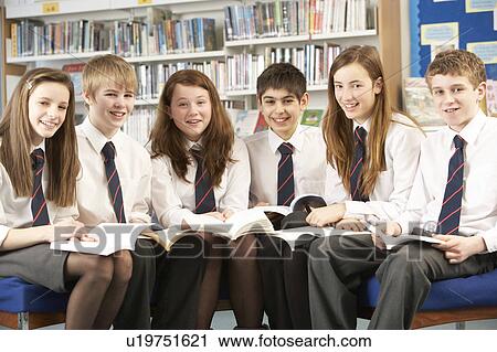 Stock Image - Teenage Students In Library Reading Books. Fotosearch
