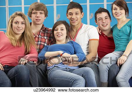Stock Image - Teenage Students Relaxing By Lockers In School. Fotosearch