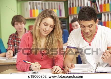 Stock Image - Teenage Students Studying In Classroom. Fotosearch