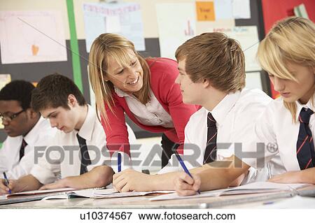 Stock Photo - Teenage Students Studying In Classroom With Teacher. Fotosearch