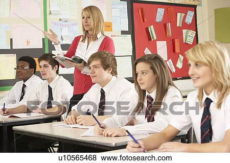 Stock Photo - Teenage Students Studying In Classroom With Teacher. Fotosearch