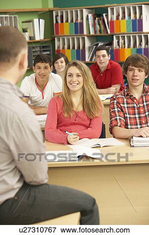 Stock Photo - Teenage Students Studying In Classroom With Tutor. Fotosearch