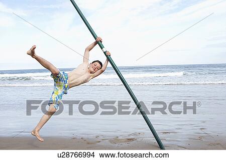 Picture - Teenagers playing on beach. Fotosearch