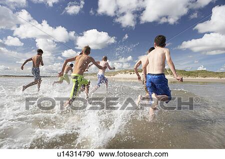 Teenagers playing on beach View Large Photo Image Stock Image - Teenagers playing on beach. Fotosearch