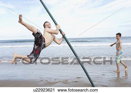 Stock Image - Teenagers playing on beach. Fotosearch