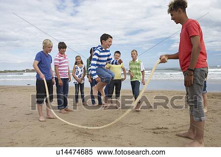 Stock Photography - Teenagers playing skipping rope. Fotosearch