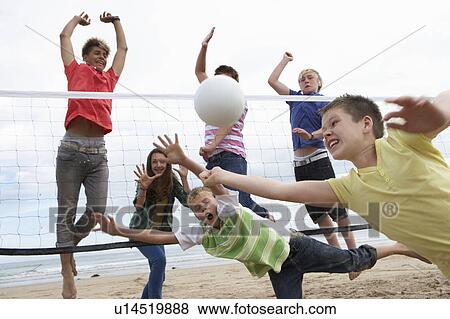 Stock Photo - Teenagers playing volleyball. Fotosearch