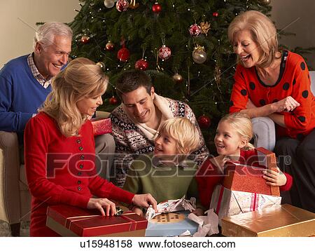 Three Generation Family Opening Christmas Gifts At Home View Large Photo Image Stock Photo - Three Generation Family Opening Christmas Gifts At Home. Fotosearch
