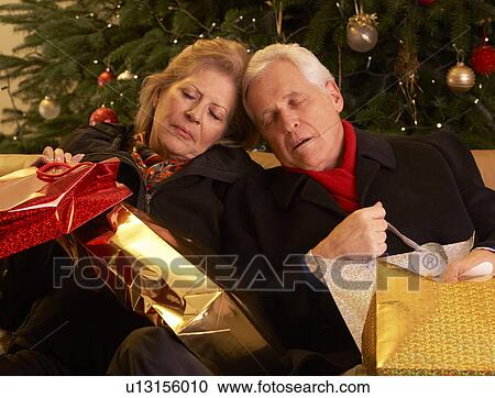 Stock Image - Tired Senior Couple Returning After Christmas Shopping Trip. Fotosearch