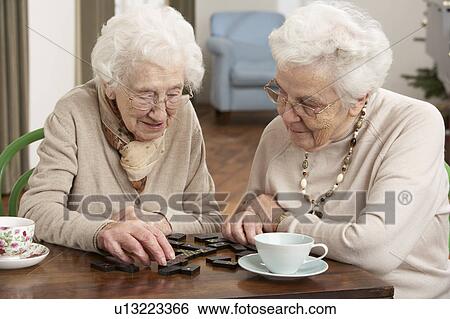 Two Senior Women Playing Dominoes At Day Care Centre View Large Photo Image Stock Photograph - Two Senior Women Playing Dominoes At Day Care Centre. Fotosearch