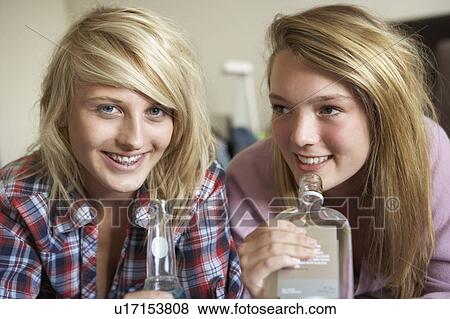 Two Teenage Girls Sitting On Sofa At Home Drinking Alcohol View Large Photo Image Stock Photo - Two Teenage Girls Sitting On Sofa At Home Drinking Alcohol. Fotosearch
