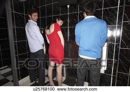 Woman and two men standing at mens urinal View Large Photo Image Stock Image - Woman and two men standing at mens urinal. Fotosearch