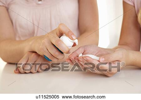 Stock Photography - Woman hand applying hand sanitizer. Fotosearch