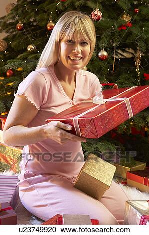 Woman Opening Christmas Present In Front Of Tree View Large Photo Image Stock Image - Woman Opening Christmas Present In Front Of Tree. Fotosearch