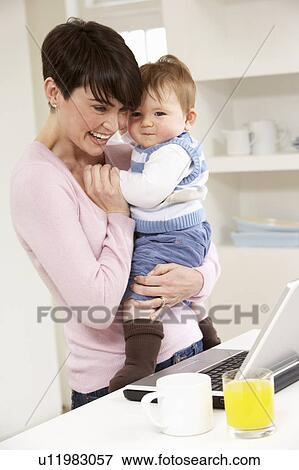 Woman With Baby Working From Home Using Laptop View Large Photo Image Stock Photo - Woman With Baby Working From Home Using Laptop. Fotosearch
