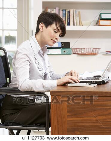 Stock Image - Woman Working From Home Using Laptop. Fotosearch