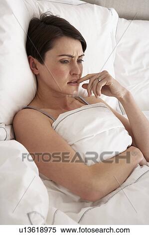 Stock Photography - Worried Woman Laying Awake In Bed. Fotosearch