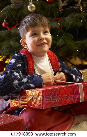 Young Boy Opening Christmas Present In Front Of Tree View Large Photo Image Stock Image - Young Boy Opening Christmas Present In Front Of Tree. Fotosearch