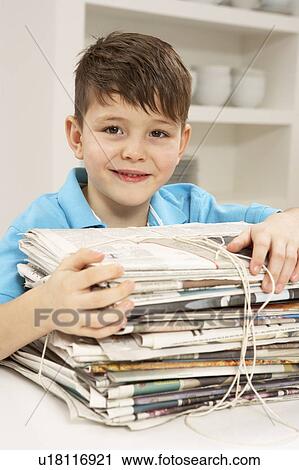 Stock Image - Young Boy Recyling Newspapers At Home. Fotosearch