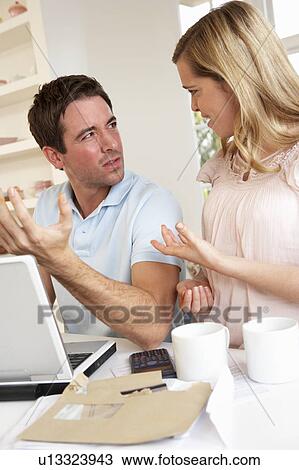 Stock Image - Young couple discussing their finance over laptop computer. Fotosearch