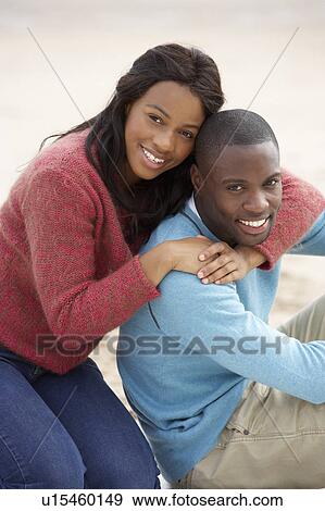 Stock Photo - Young couple Embracing on beach. Fotosearch
