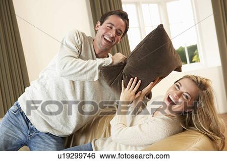Young couple having fun laughing on sofa View Large Photo Image Stock Photograph - Young couple having fun laughing on sofa. Fotosearch