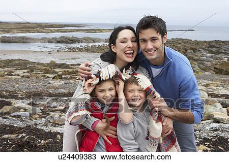 Stock Image - Young couple on beach with umbrella. Fotosearch