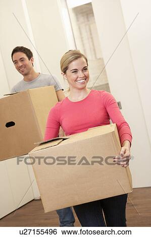 Young couple on moving day carrying cardboard boxes View Large Photo Image Stock Photograph - Young couple on moving day carrying cardboard boxes. Fotosearch
