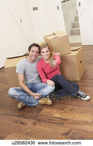Young couple on moving day sitting with cardboard boxes View Large Photo Image Stock Image - Young couple on moving day sitting with cardboard boxes. Fotosearch
