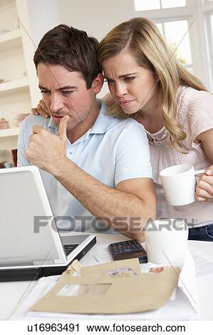 Young couple thinking and looking at a laptop computer View Large Photo Image Stock Image - Young couple thinking and looking at a laptop computer. Fotosearch