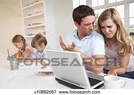 Stock Photo - Young couple thinking and looking at a laptop computer. Fotosearch
