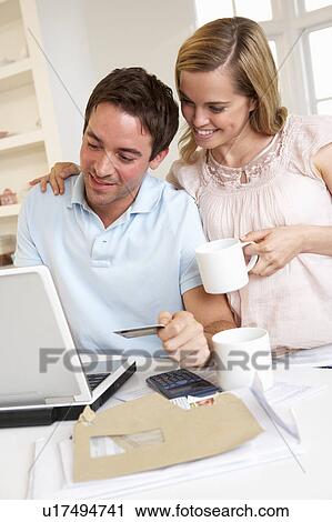 Young couple using credit card on the internet View Large Photo Image Stock Image - Young couple using credit card on the internet. Fotosearch