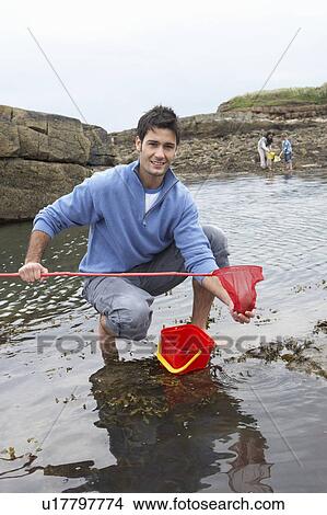Young family at beach collecting shells View Large Photo Image Picture - Young family at beach collecting shells. Fotosearch