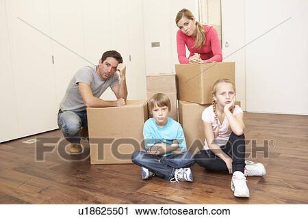 Young family looking upset among boxes View Large Photo Image Stock Image - Young family looking upset among boxes. Fotosearch