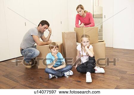 Young family looking upset among boxes View Large Photo Image Stock Photo - Young family looking upset among boxes. Fotosearch