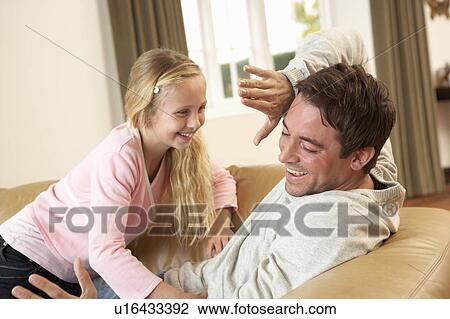Young father with girl having fun on sofa View Large Photo Image Stock Image - Young father with girl having fun on sofa. Fotosearch