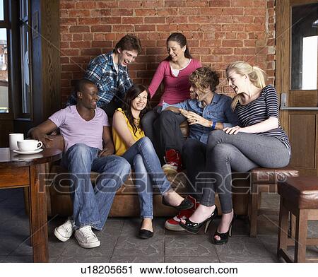 Stock Image - Young friends in cafÃ©. Fotosearch