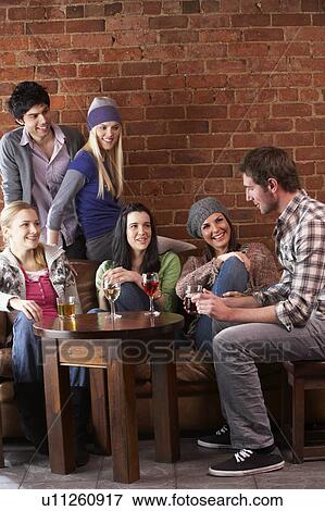 Stock Photo - Young friends in cafÃ©. Fotosearch