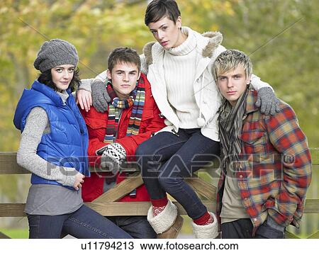 Young friends sitting on fence View Large Photo Image Stock Image - Young friends sitting on fence. Fotosearch