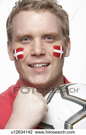Stock Image - Young Male Football Fan With Danish Flag Painted On Face. Fotosearch