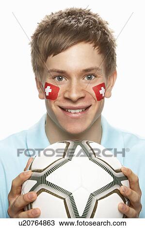 Stock Image - Young Male Football Fan With Swiss Flag Painted On Face. Fotosearch