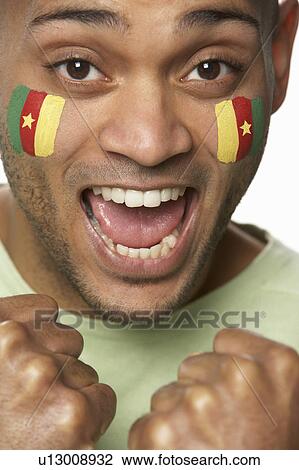 Stock Image - Young Male Sports Fan With Cameroon Flag Painted On Face. Fotosearch