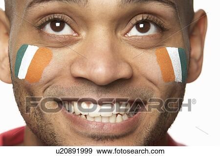Stock Photo - Young Male Sports Fan With Ivory Coast Flag Painted On Face. Fotosearch