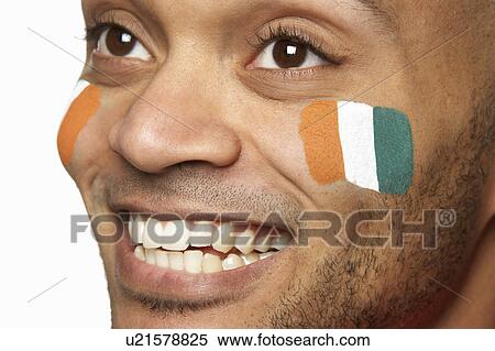Stock Photography - Young Male Sports Fan With Ivory Coast Flag Painted On Face. Fotosearch